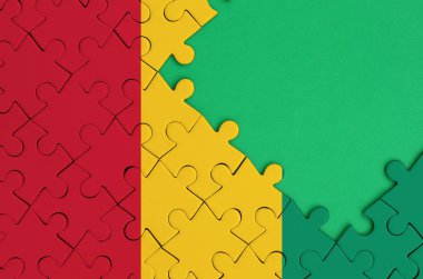 Gine bayrağı tamamlanmış bir jigsaw bulmaca ücretsiz yeşil kopya alanı sağ tarafında ile tasvir edilir.