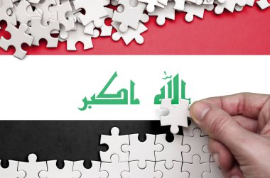 Irak bayrağı üzerinde insan el kıvrımlar bir bulmaca beyaz renk bir tablo üzerinde tasvir.