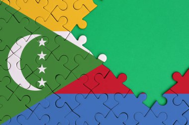 Komor bayrağı tamamlanmış bir jigsaw bulmaca ücretsiz yeşil kopya alanı sağ tarafında ile tasvir edilir.