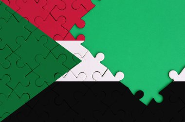Sudan bayrağı tamamlanmış bir jigsaw bulmaca ücretsiz yeşil kopya alanı sağ tarafında ile tasvir edilir.