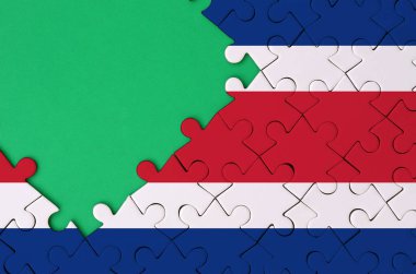 Kosta Rika bayrağı tamamlanmış bir jigsaw bulmaca ücretsiz yeşil kopya alanı sol tarafında ile tasvir edilir.