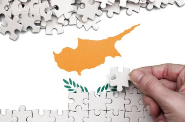 Kıbrıs bayrağı üzerinde insan el kıvrımlar bir bulmaca beyaz renk bir tablo üzerinde tasvir.