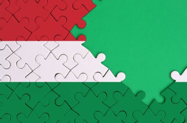 Macaristan bayrağı tamamlanmış bir jigsaw bulmaca ücretsiz yeşil kopya alanı sağ tarafında ile tasvir edilir.