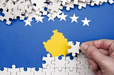 Kosova bayrağı üzerinde insan el kıvrımlar bir bulmaca beyaz renk bir tablo üzerinde tasvir.