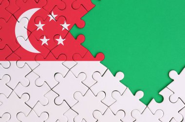 Singapur bayrağı tamamlanmış bir jigsaw bulmaca ücretsiz yeşil kopya alanı sağ tarafında ile tasvir edilir.