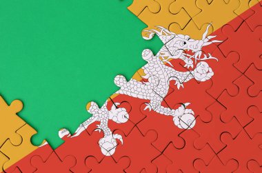 Bhutan bayrağı tamamlanmış bir jigsaw bulmaca ücretsiz yeşil kopya alanı sol tarafında ile tasvir edilir.
