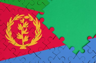 Eritre bayrağı tamamlanmış bir jigsaw bulmaca ücretsiz yeşil kopya alanı sağ tarafında ile tasvir edilir.