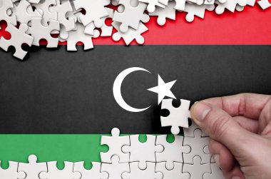 Libya bayrağı üzerinde insan el kıvrımlar bir bulmaca beyaz renk bir tablo üzerinde tasvir.