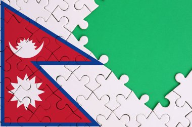 Nepal bayrağı tamamlanmış bir jigsaw bulmaca ücretsiz yeşil kopya alanı sağ tarafında ile tasvir edilir.