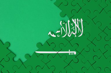Suudi Arabistan bayrağı tamamlanmış bir jigsaw bulmaca ücretsiz yeşil kopya alanı sol tarafında ile tasvir edilir.