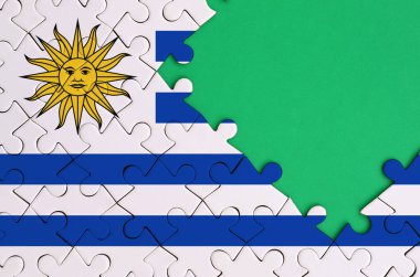 Uruguay bayrağı tamamlanmış bir jigsaw bulmaca ücretsiz yeşil kopya alanı sağ tarafında ile tasvir edilir.