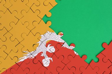 Bhutan bayrağı tamamlanmış bir jigsaw bulmaca ücretsiz yeşil kopya alanı sağ tarafında ile tasvir edilir.