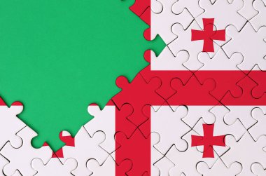 Georgia bayrağı tamamlanmış bir jigsaw bulmaca ücretsiz yeşil kopya alanı sol tarafında ile tasvir edilir.
