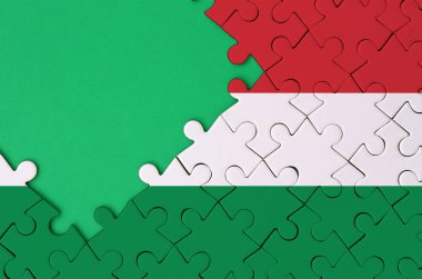 Macaristan bayrağı tamamlanmış bir jigsaw bulmaca ücretsiz yeşil kopya alanı sol tarafında ile tasvir edilir.