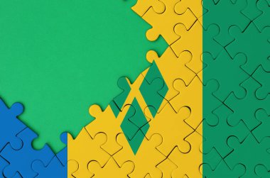 Saint Vincent ve Grenadinler bayrağı tamamlanmış bir jigsaw bulmaca ücretsiz yeşil kopya alanı sol tarafında ile tasvir edilir.