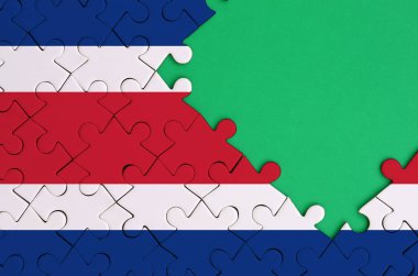 Kosta Rika bayrağı tamamlanmış bir jigsaw bulmaca ücretsiz yeşil kopya alanı sağ tarafında ile tasvir edilir.