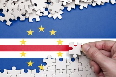 Cabo verde bayrağı üzerinde insan el kıvrımlar bir bulmaca beyaz renk bir tablo üzerinde tasvir.