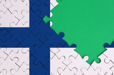 Finlandiya bayrağı tamamlanmış bir jigsaw bulmaca ücretsiz yeşil kopya alanı sağ tarafında ile tasvir edilir.