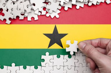 Gana bayrağı üzerinde insan el kıvrımlar bir bulmaca beyaz renk bir tablo üzerinde tasvir.