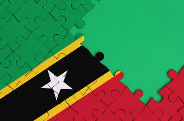 Saint Kitts ve Nevis bayrağı tamamlanmış bir jigsaw bulmaca ücretsiz yeşil kopya alanı sağ tarafında ile tasvir edilir.