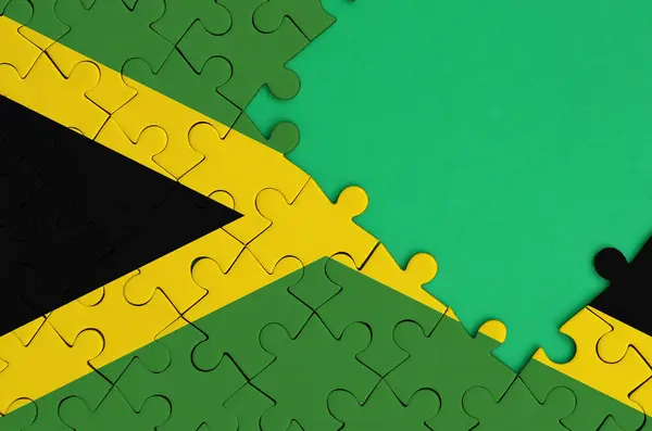ジャマイカ国旗が右側にある緑の無料コピー スペースを持つ完成したジグソー パズルに描かれています — ストック写真
