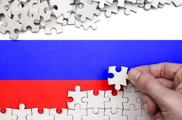 Russia Flag Depicted Table Which Human Hand Folds Puzzle White — Stock Photo, Image