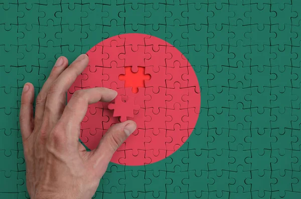 バングラデシュの国旗は 人間の手を折る完了パズルに描かれています — ストック写真