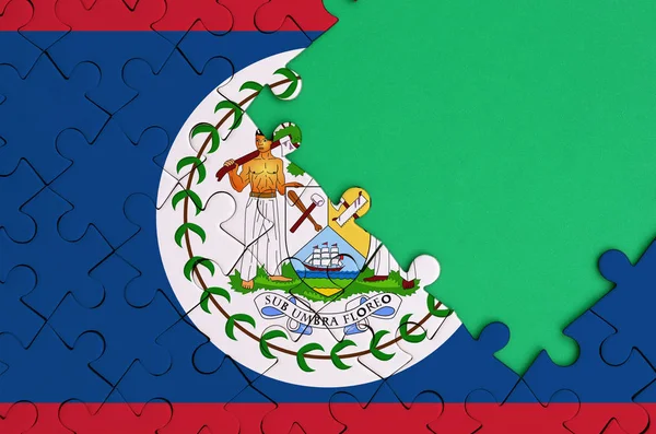 ベリーズの国旗は 右側にある緑の無料コピー スペースを持つ完成したジグソー パズルに描かれています — ストック写真