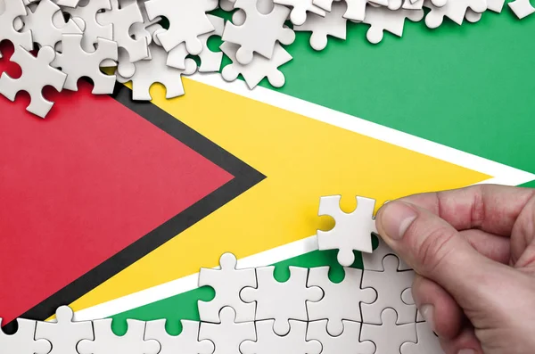 Guyana Flag Depicted Table Which Human Hand Folds Puzzle White — Stock Photo, Image