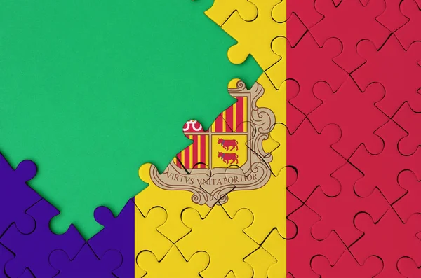 アンドラの国旗は 左側にある緑の無料コピー スペースを持つ完成したジグソー パズルに描かれています — ストック写真