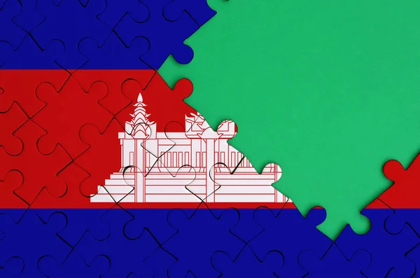 カンボジアの国旗は 右側にある緑の無料コピー スペースを持つ完成したジグソー パズルに描かれています — ストック写真