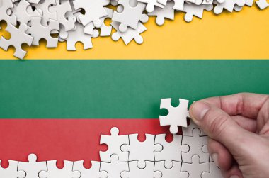 Litvanya bayrağı üzerinde insan el kıvrımlar bir bulmaca beyaz renk bir tablo üzerinde tasvir.