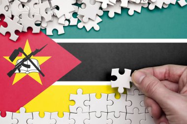 Mozambik bayrağı üzerinde insan el kıvrımlar bir bulmaca beyaz renk bir tablo üzerinde tasvir.