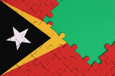 Timor Leste bayrağı tamamlanmış bir jigsaw bulmaca ücretsiz yeşil kopya alanı sağ tarafında ile tasvir edilir.