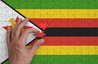 Zimbabve bayrağı yukarı doğru elini tamamlar bir bulmaca, tasvir.