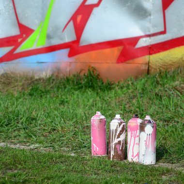 Birkaç kullanılan boya yere duvara yakın bir güzel grafiti resimle yalan. Sokak sanatı ve vandalizm kavramı.