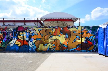 Sokak sanatı. Tam tamamlanan grafiti resmi bulunan bir çizgi film karakteri ile bej ve turuncu tonları arka plan görüntü.