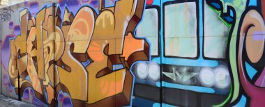 Sokak sanatı. Tam tamamlanan grafiti resmi bulunan bir metro treninin ile bej ve turuncu tonları arka plan görüntü.