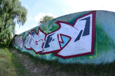 Sokak sanatı. Arka plan görüntüsü tam tamamlanan grafiti resmi bulunan bir rahiplik krom dolgu, arka planı yeşil ve kırmızı özetliyor. Balıkgözü fotoğraf.