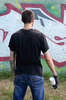 Genç mecnuna bir sprey ile standları bir beton duvara grafiti boya ile olabilir. Yasadışı vandalizm kavramı. Sokak sanatı.