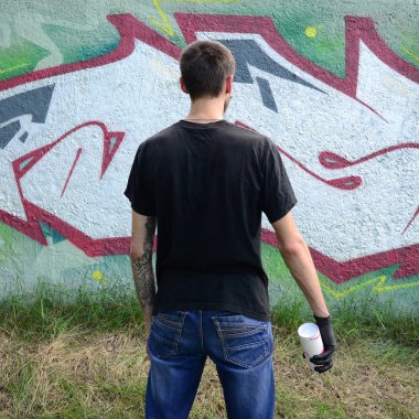 Genç mecnuna bir sprey ile standları bir beton duvara grafiti boya ile olabilir. Yasadışı vandalizm kavramı. Sokak sanatı.