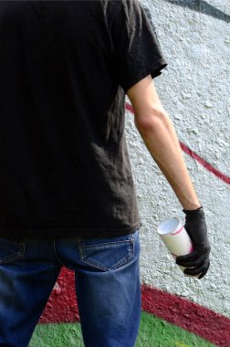 Genç mecnuna bir sprey ile standları bir beton duvara grafiti boya ile olabilir. Yasadışı vandalizm kavramı. Sokak sanatı.