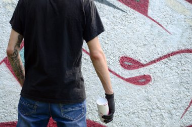 Genç mecnuna bir sprey ile standları bir beton duvara grafiti boya ile olabilir. Yasadışı vandalizm kavramı. Sokak sanatı.