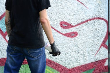 Genç mecnuna bir sprey ile standları bir beton duvara grafiti boya ile olabilir. Yasadışı vandalizm kavramı. Sokak sanatı.
