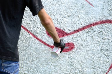 Genç mecnuna beton duvara grafiti boyar. Yasadışı vandalizm kavramı. Sokak sanatı.