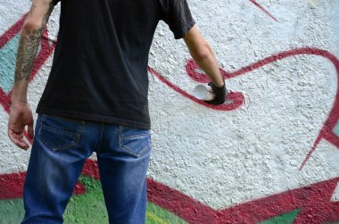 Genç mecnuna beton duvara grafiti boyar. Yasadışı vandalizm kavramı. Sokak sanatı.