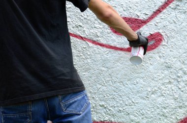 Genç mecnuna beton duvara grafiti boyar. Yasadışı vandalizm kavramı. Sokak sanatı.