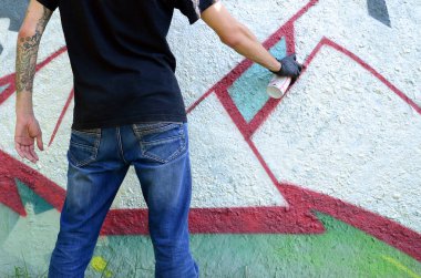 Genç mecnuna beton duvara grafiti boyar. Yasadışı vandalizm kavramı. Sokak sanatı.
