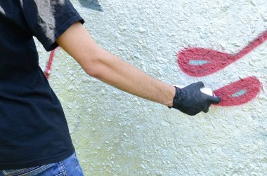 Genç mecnuna beton duvara grafiti boyar. Yasadışı vandalizm kavramı. Sokak sanatı.