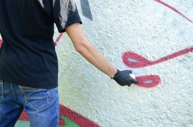 Genç mecnuna beton duvara grafiti boyar. Yasadışı vandalizm kavramı. Sokak sanatı.